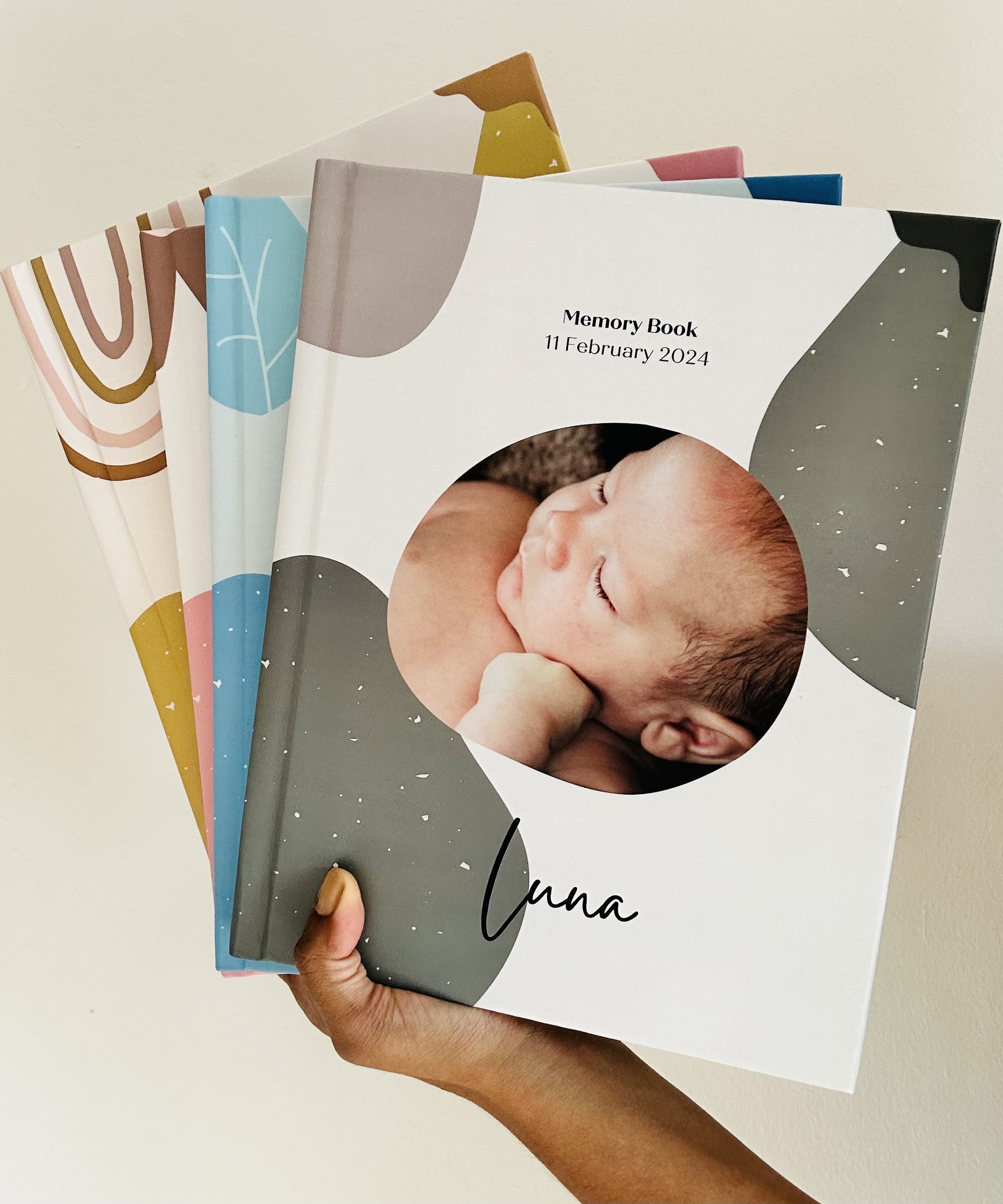A beautifully printed Dujourbaby memory book with a baby photo and custom name on the cover